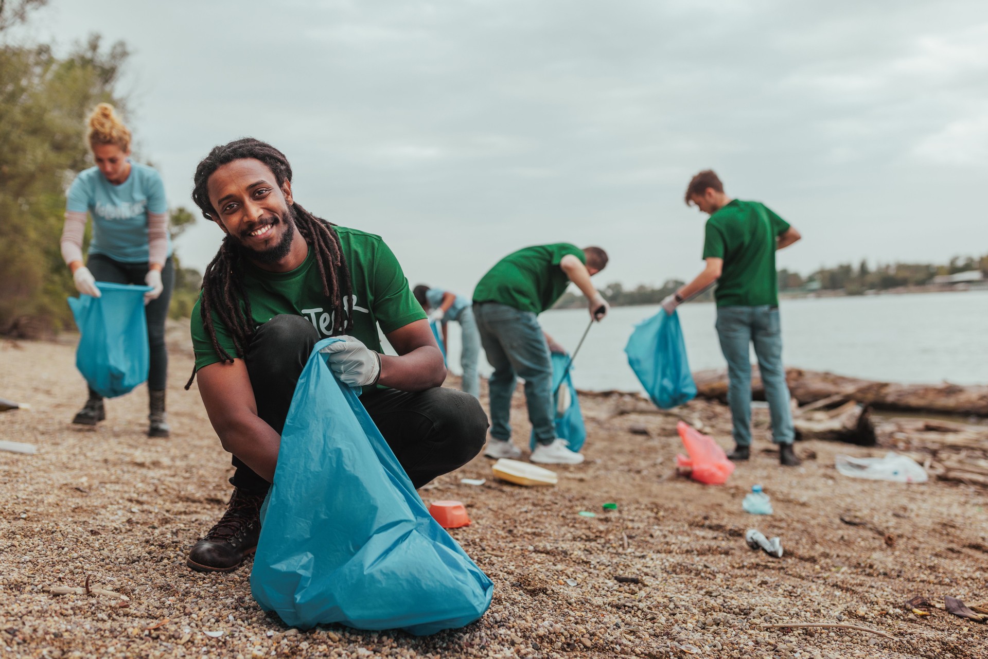 Volunteer smiling an collecting plastic on earth day